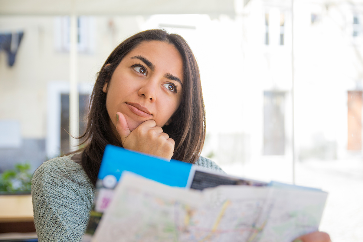 Person holding a map, looking thoughtful and focused.