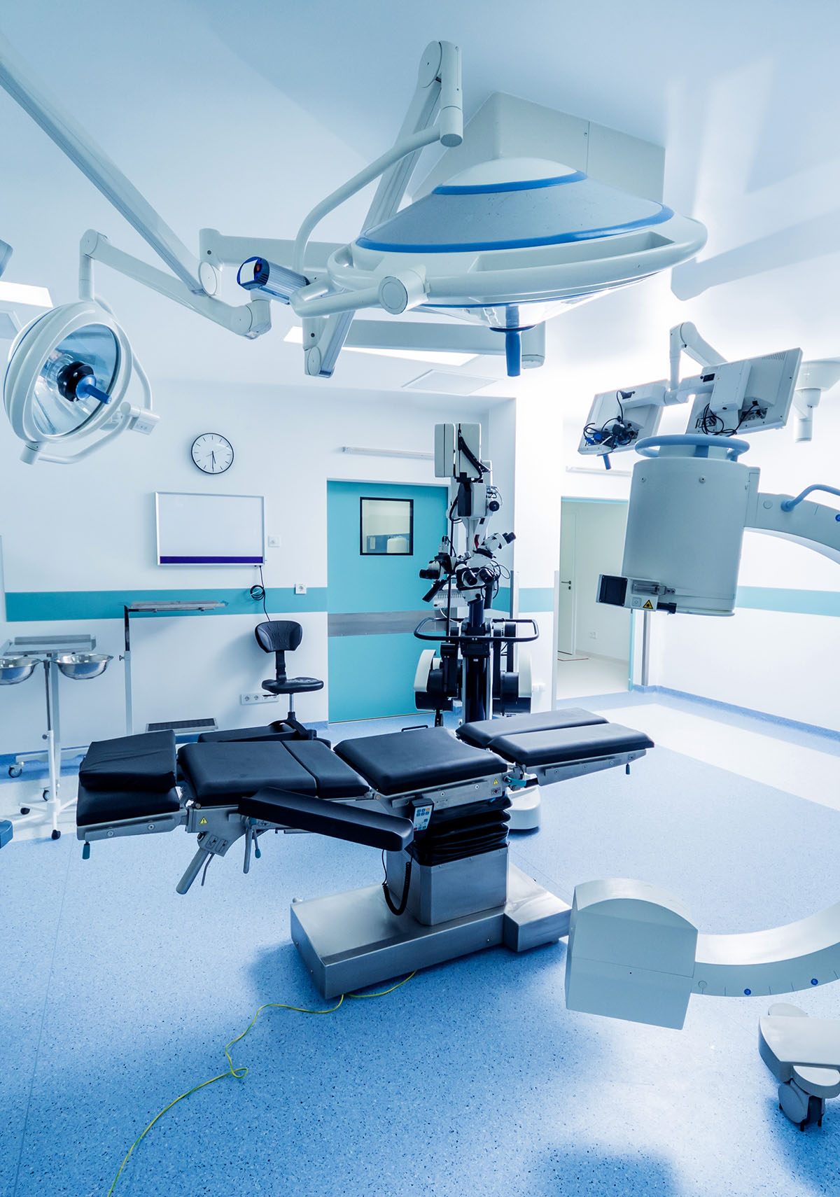 Modern operating room with surgical bed, lighting, and advanced medical equipment.
